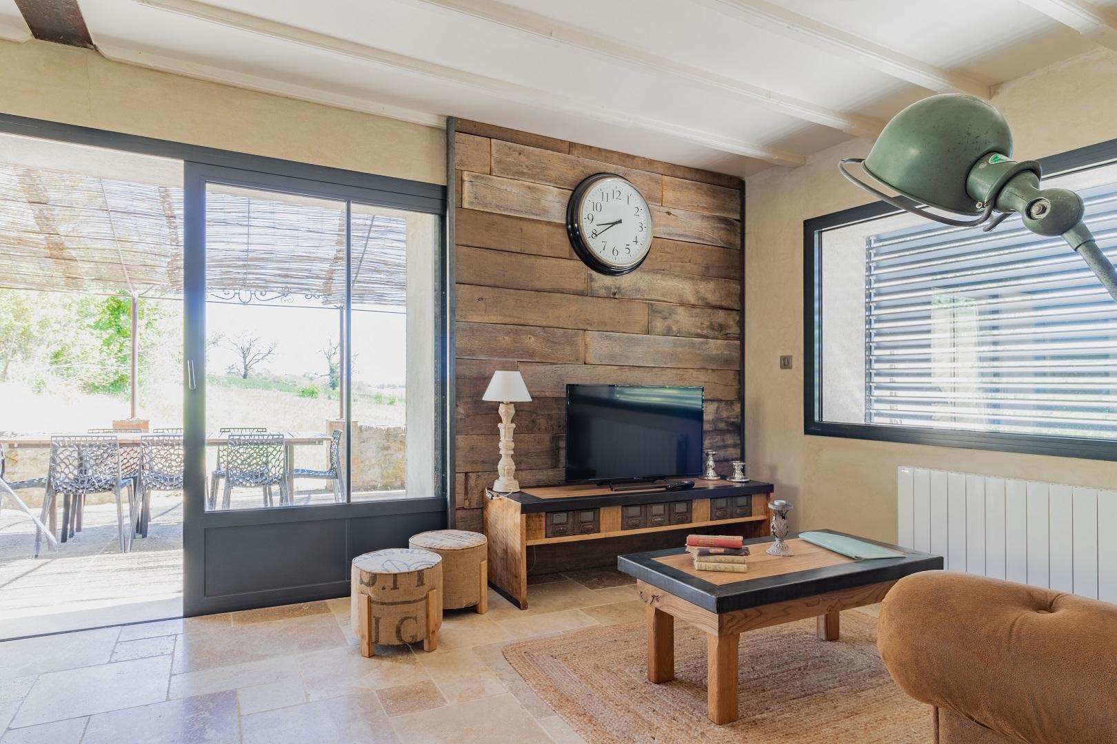 Séjour avec baie coulissante donnant sur la terrasse ombragée
