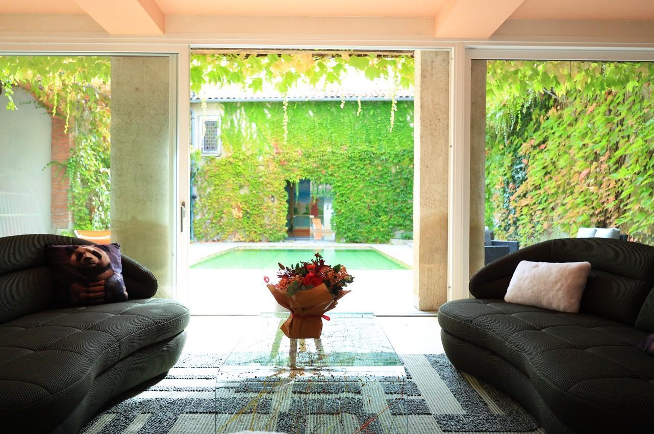 Vue sur le patio et sa piscine depuis le salon d'accueil